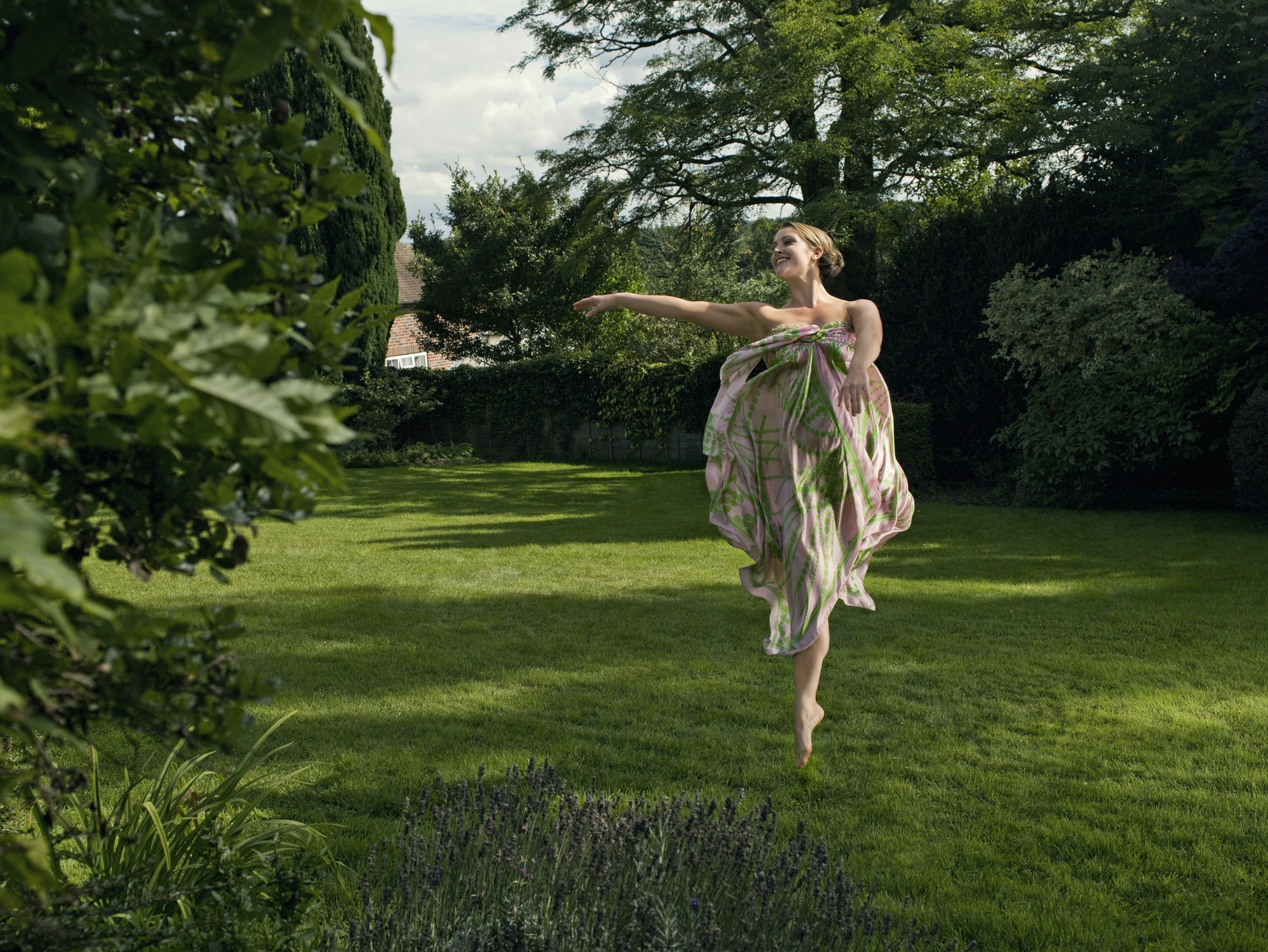 A young woman dancing in a garden