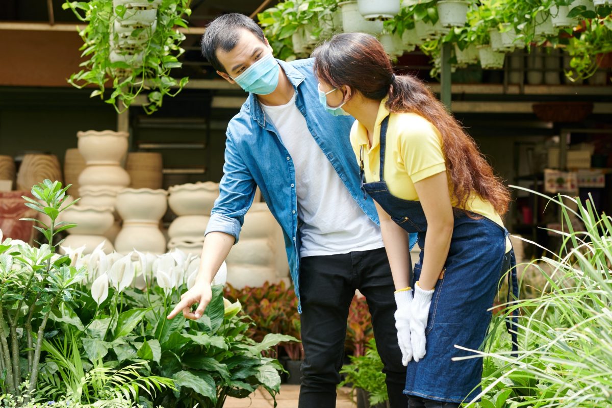 Man asking gardening center worker for help